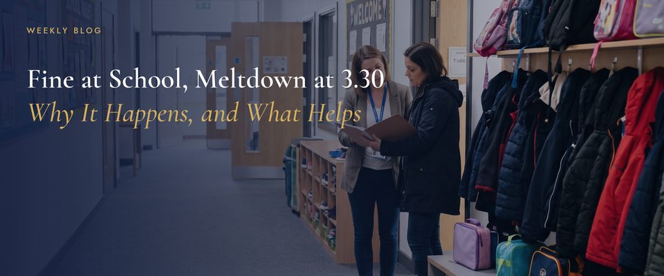 A parent and a member of staff talking in a primary school corridor lined with coats and bags at home time