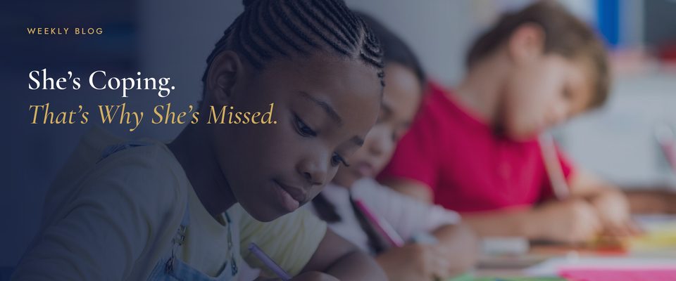 A girl focused on writing in class — why autism and ADHD in girls are so often missed