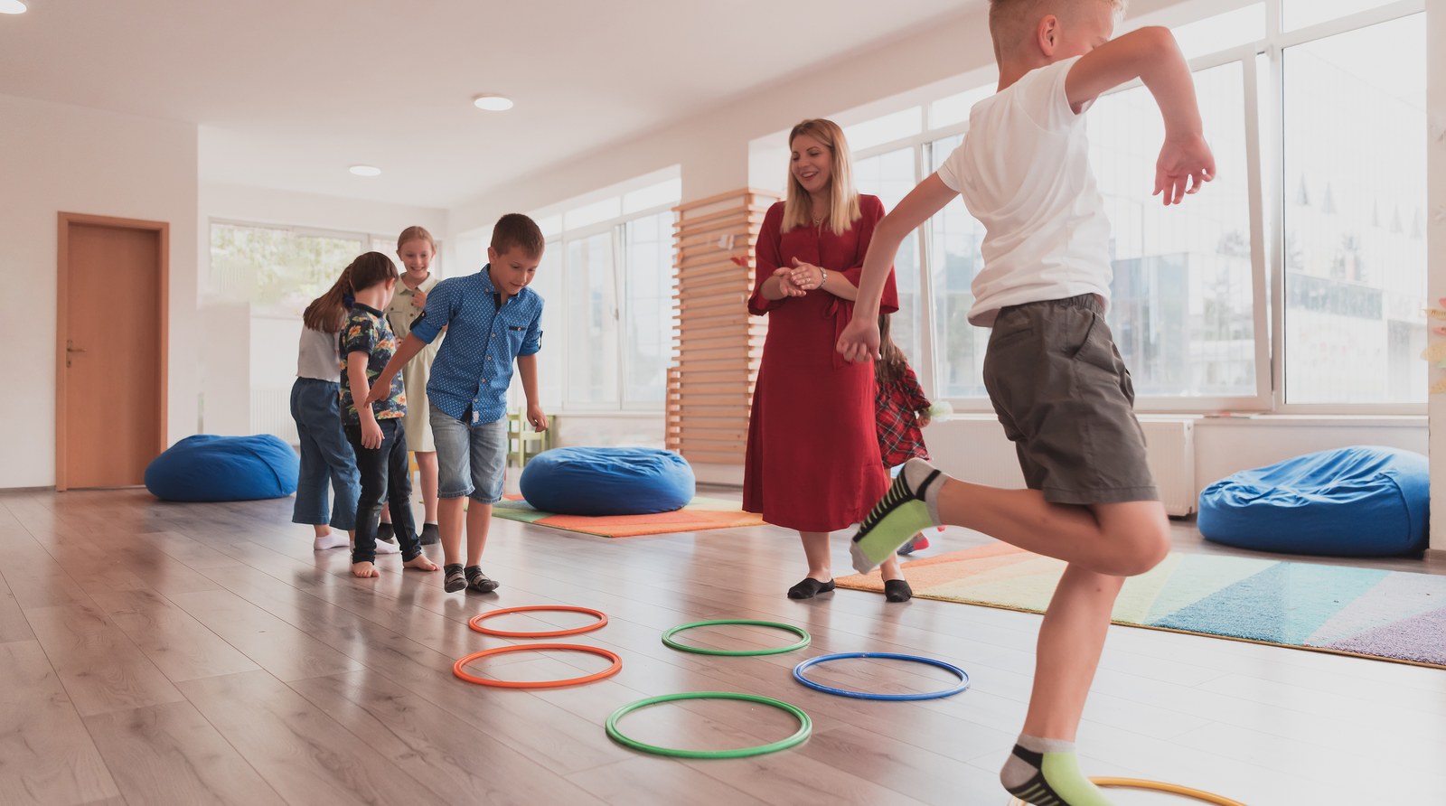 Children taking part in a movement activity in a bright classroom