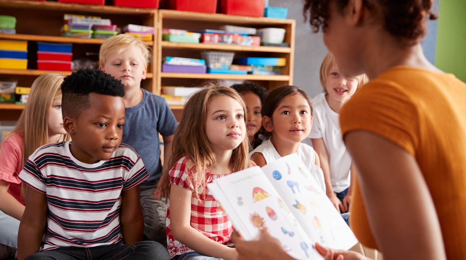 A group of young children listening attentively during story time at school