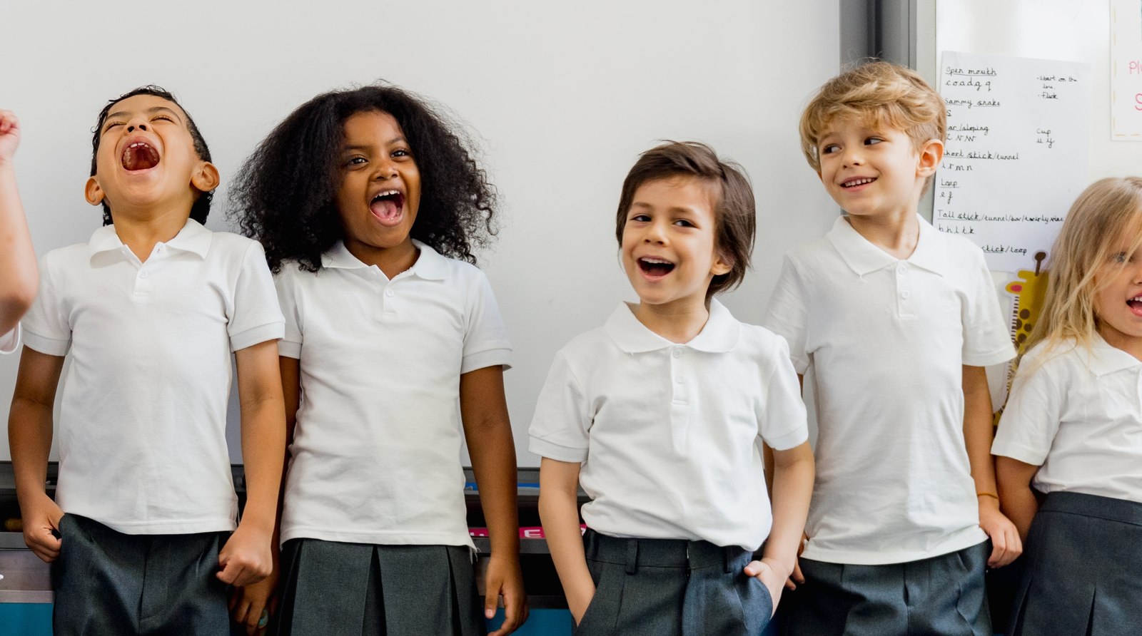 Children laughing together in a classroom — Lauren Robson asks families for their voice ahead of a CAMHS presentation