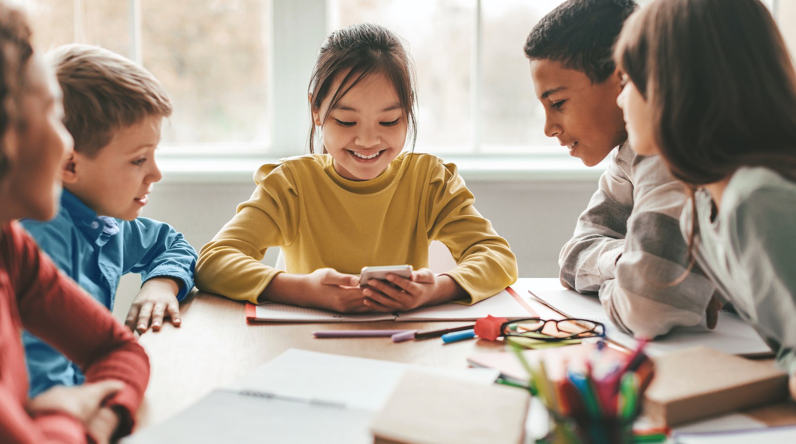 A group of children talking together at a table — waiting for an autism or ADHD assessment